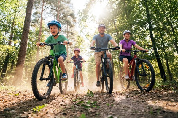 Poznański dzień rowerowy w M1 Poznań. Szczęśliwa rodzina na wycieczce rowerowej w lesie.
