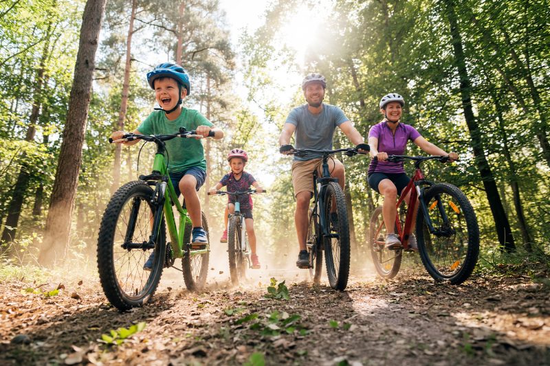 Poznański dzień rowerowy w M1 Poznań. Szczęśliwa rodzina na wycieczce rowerowej w lesie.