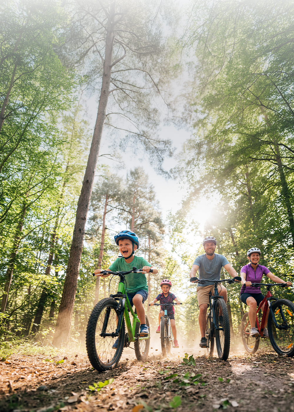 Poznański dzień rowerowy w M1 Poznań. Szczęśliwa rodzina na wycieczce rowerowej w lesie.